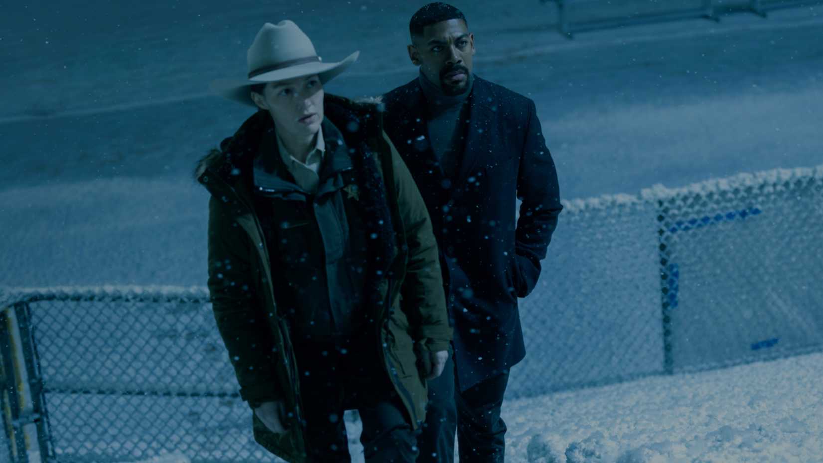 Kelly Macdonald as Sheriff Kerry and Aaron Pierre as John Stewart walking up snowy bleachers in Lanterns