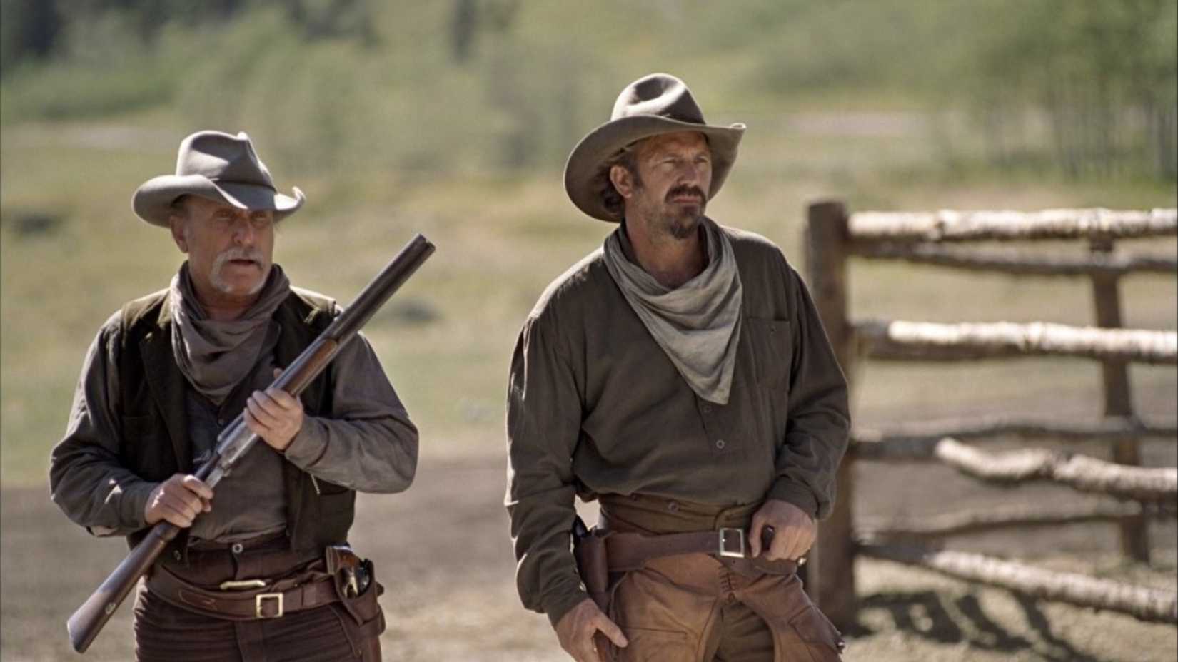 Kevin Costner and Robert Duvall stand next to each other in Open Range