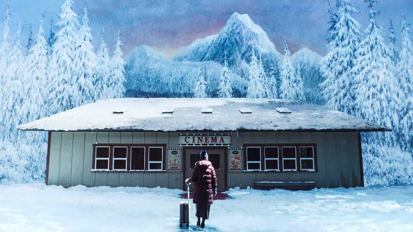 Kris with a suitcase standing before Billy's private movie theater in Teenage Sex and Death at Camp Miasma
