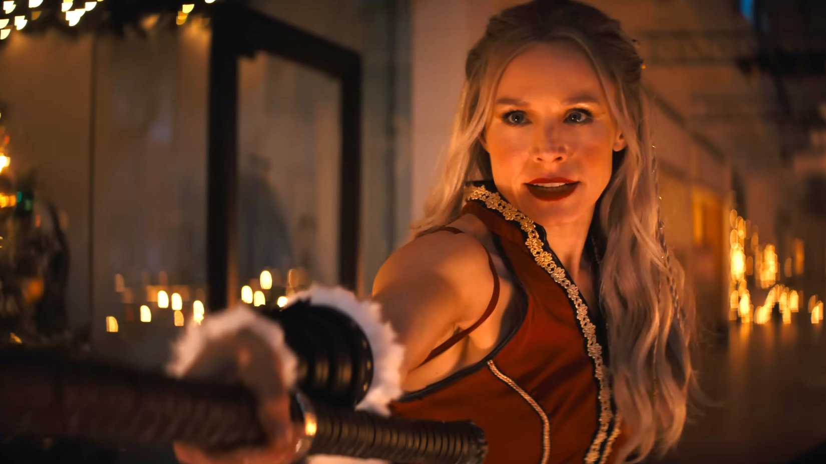Kristen Bell's Mrs. Claus smiling while holding Santa's hammer in Violent Night 2