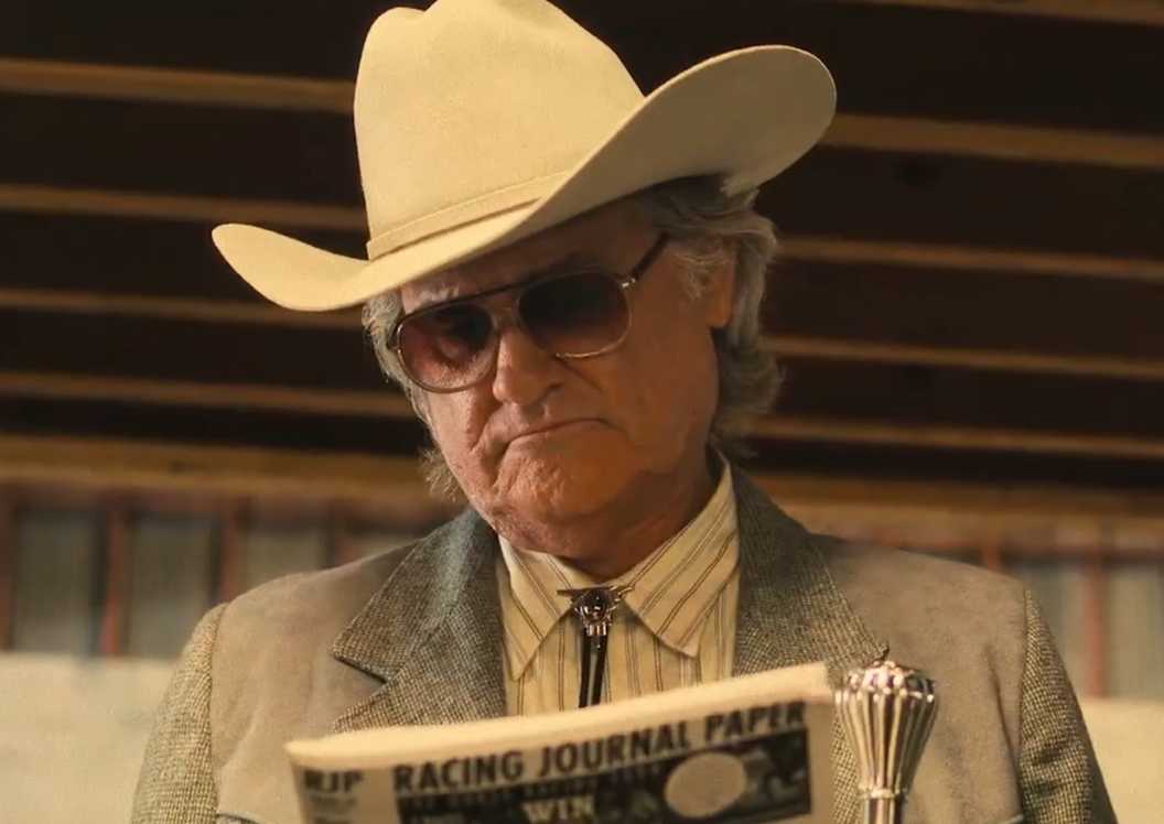 Kurt Russell looking at the newspaper in the Rivals of Amziah King