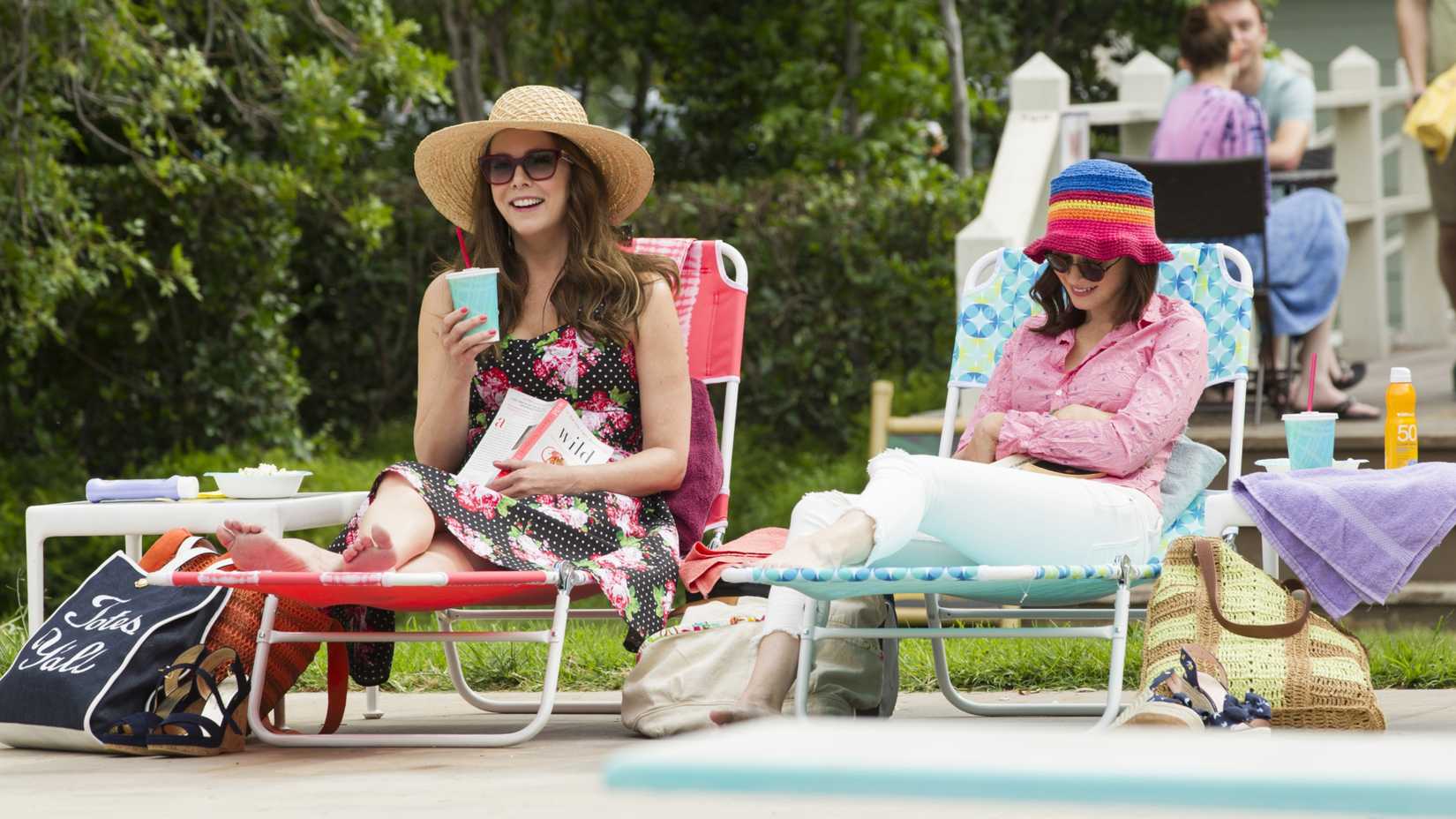 Lorelai (Lauren Graham) and Rory (Alexis Bledel) sitting by a pool in Gilmore Girls A Year in the Life
