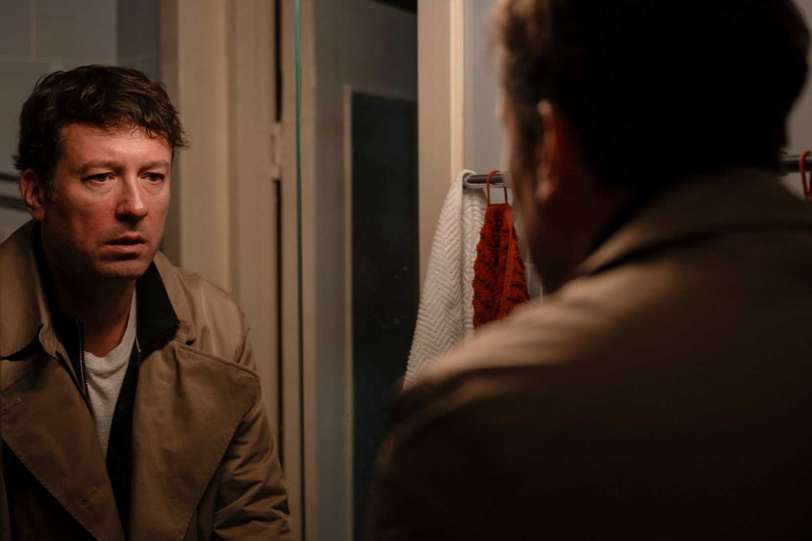 Gleb staring at himself in the mirror with a dismayed expression in Minotaur