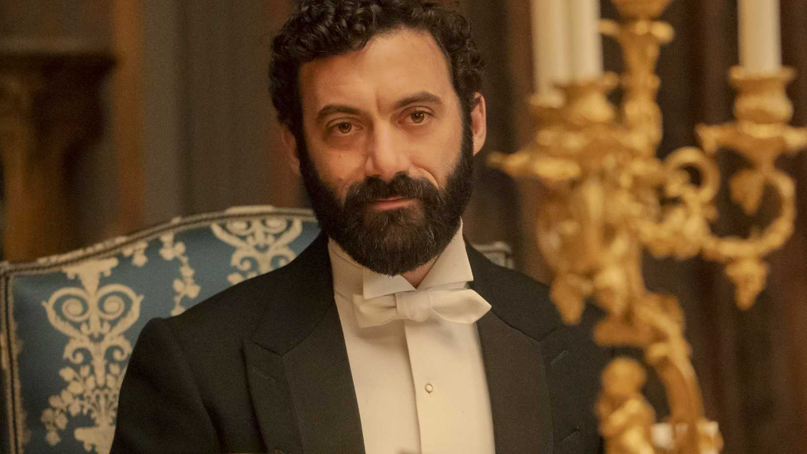Morgan Spector sitting at a fancy table in The Gilded Age