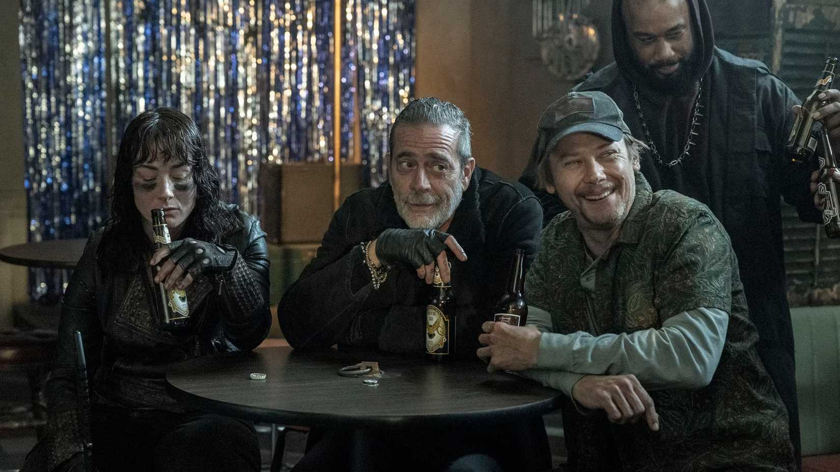 Negan (Jeffrey Dean Morgan) and Dillard (Jimmi Simpson) drinking next to other characters in The Walking Dead: Dead City
