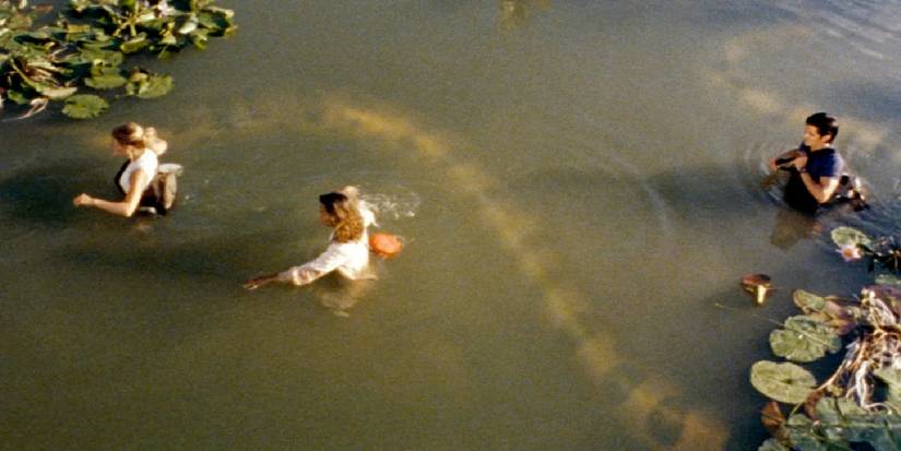 People walking through water next to a giant snake in Anacondas the Hunt for the Blood Orchid