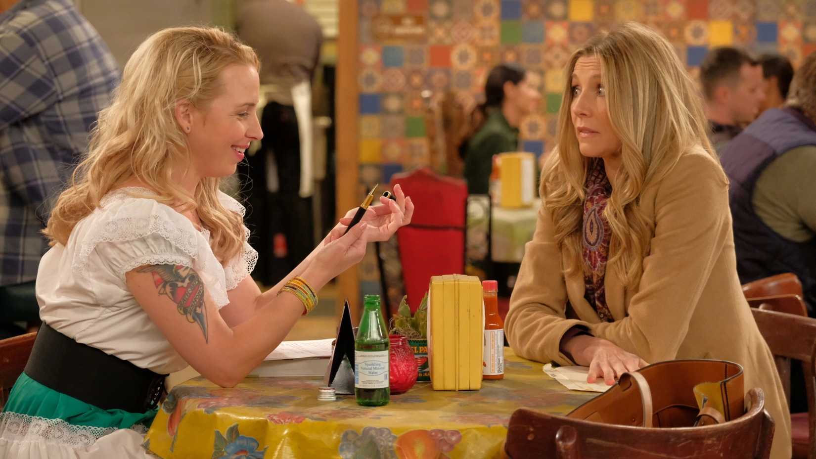 Andrea (Sarah Chalke) and Becky (Alicia Goranson) talking at a restaurant in Roseanne