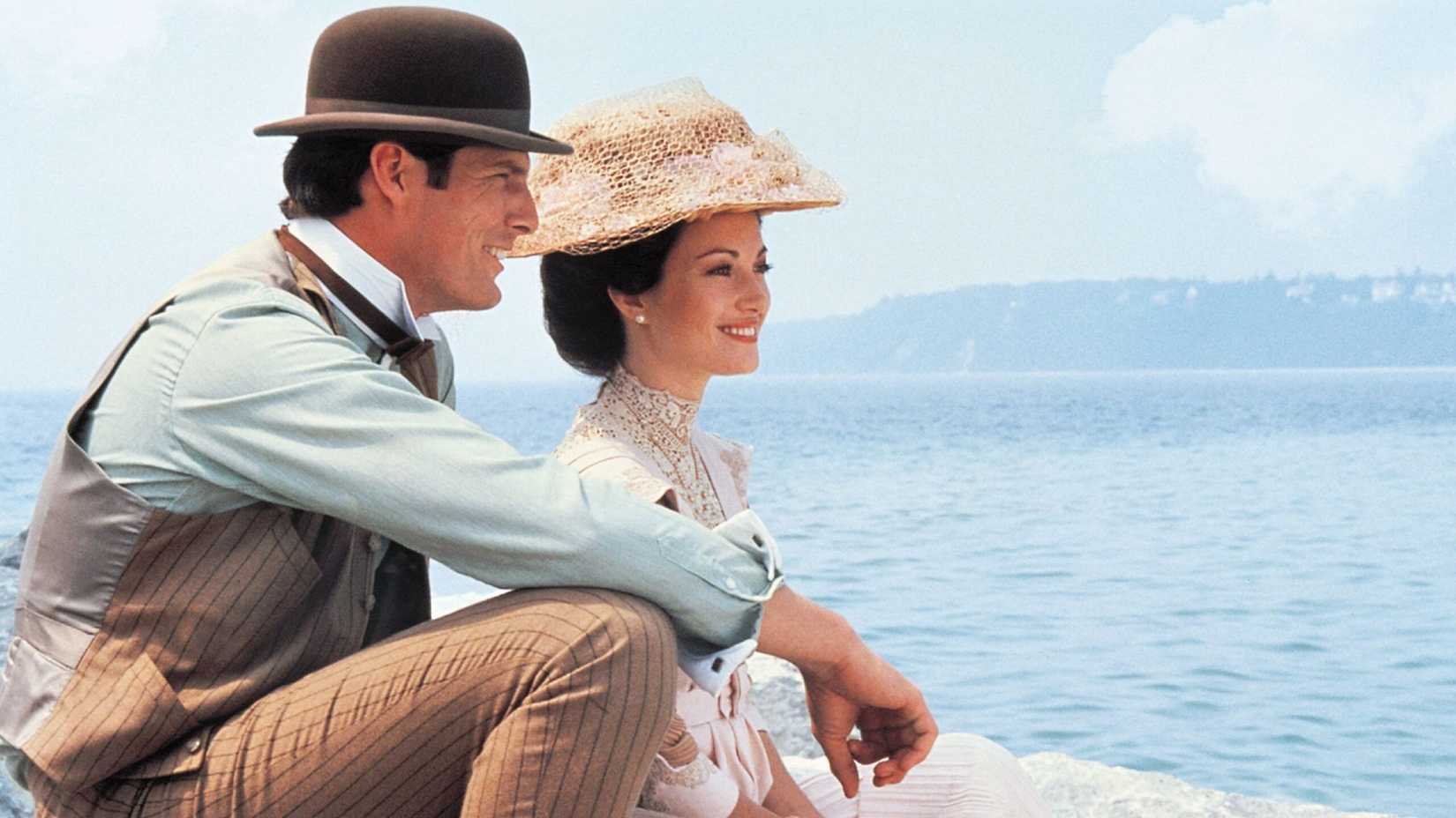 Jane Seymour and Christopher Reeve sit near the water in Somewhere in Time