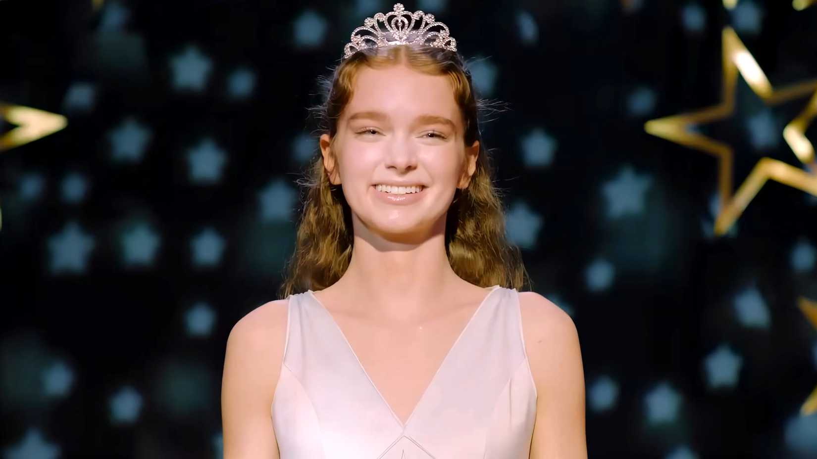 Summer H. Howell's Carrie smiling and wearing her tiara at the prom in Carrie