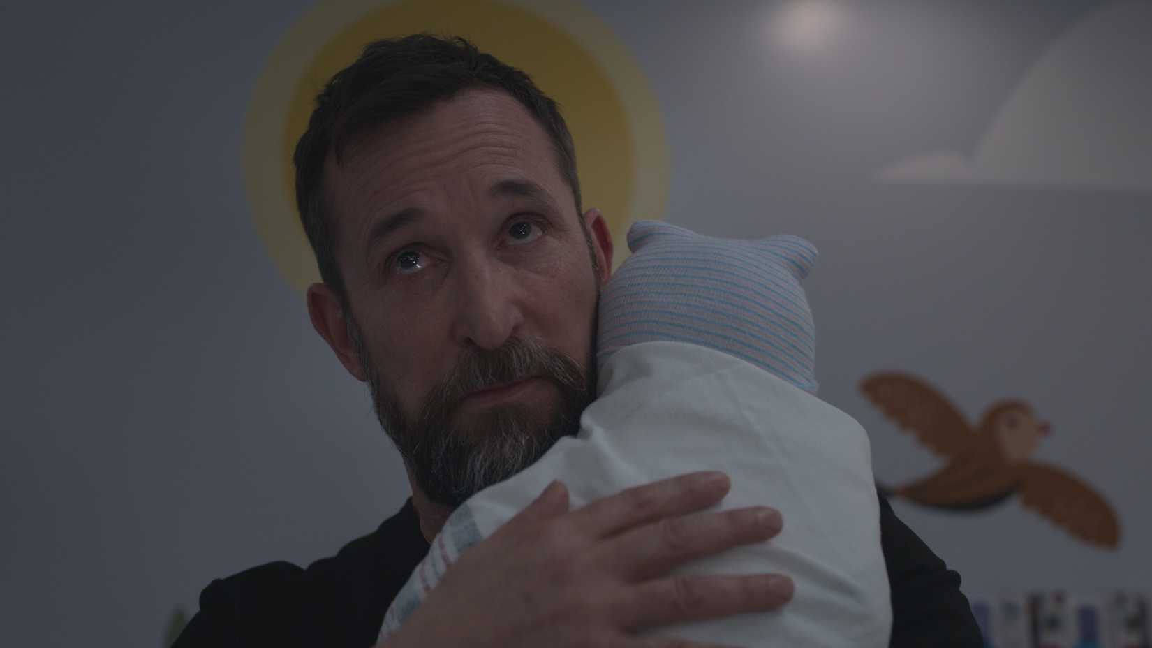 Dr Robby holding a baby in The Pitt