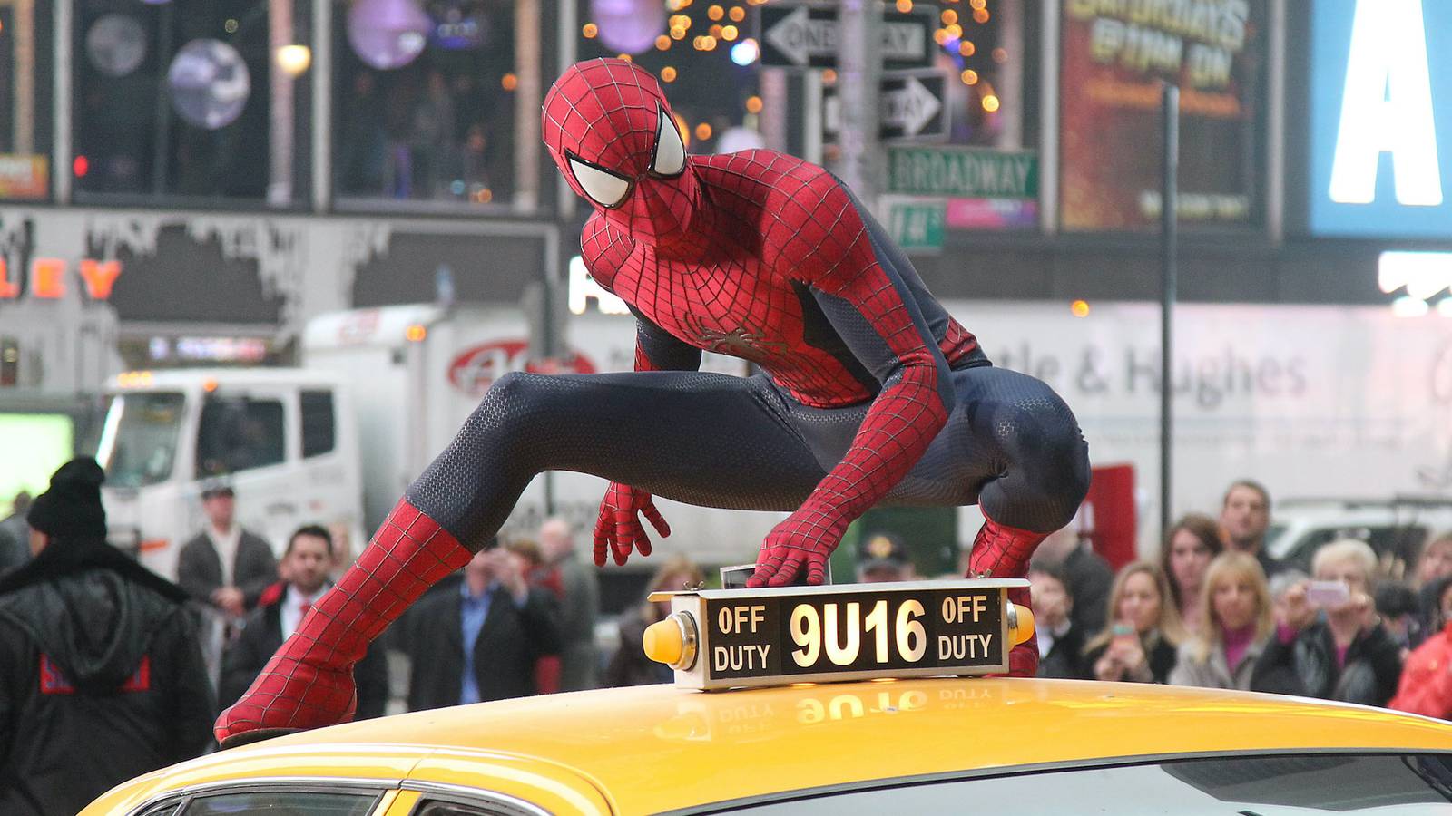 Spider-Man perched on a taxi cab in Times Square