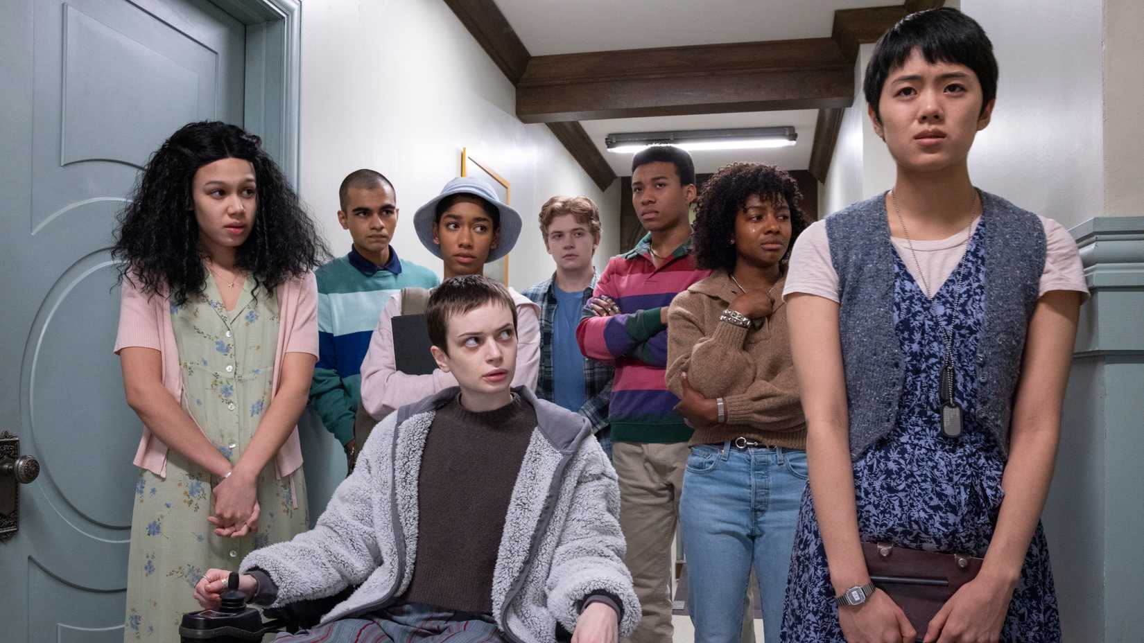 The main cast of The Midnight Club stand in a hallway in episode 3.