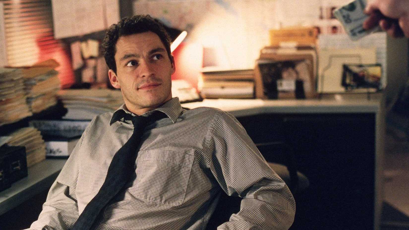 Jimmy McNulty (Dominic West) leaning back in his chair in The Wire season 1.