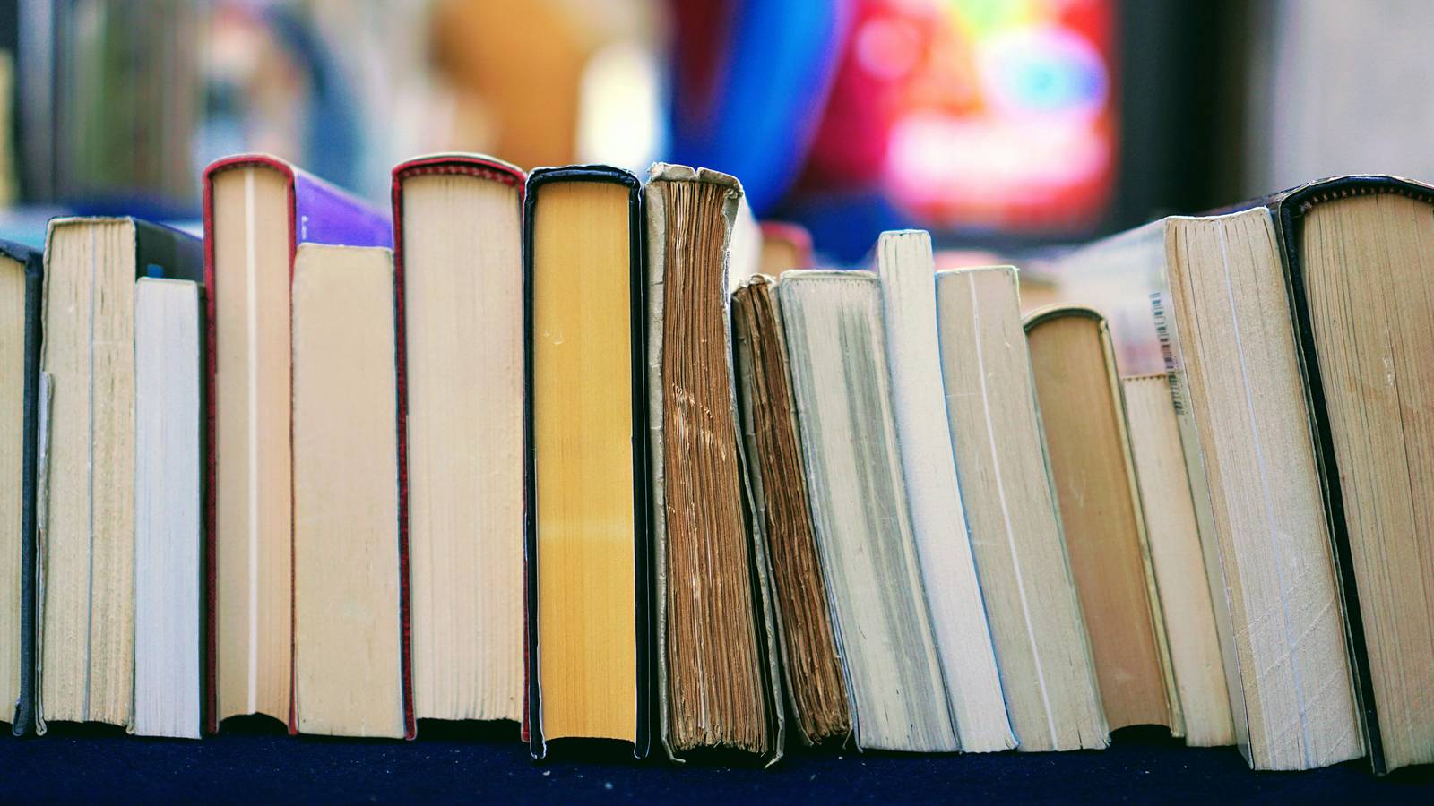 Stock image of books sitting on a table page down, spine up.
