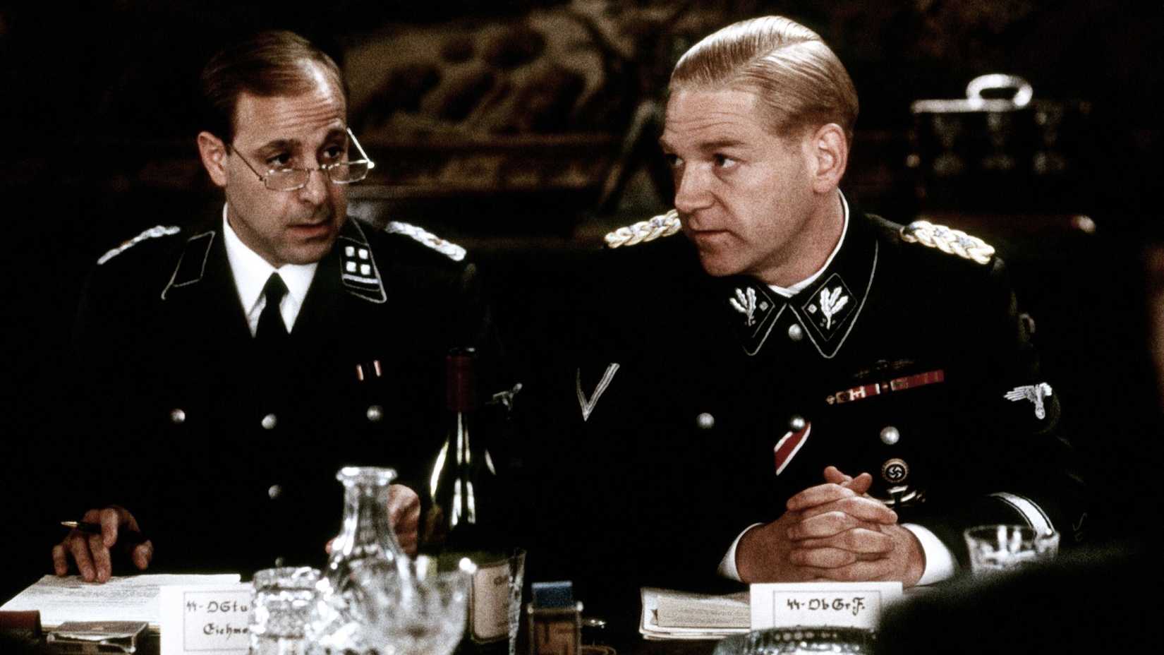 Eichmann (Stanley Tucci) sitting next to Heydrich (Kenneth Branagh) in Conspiracy.