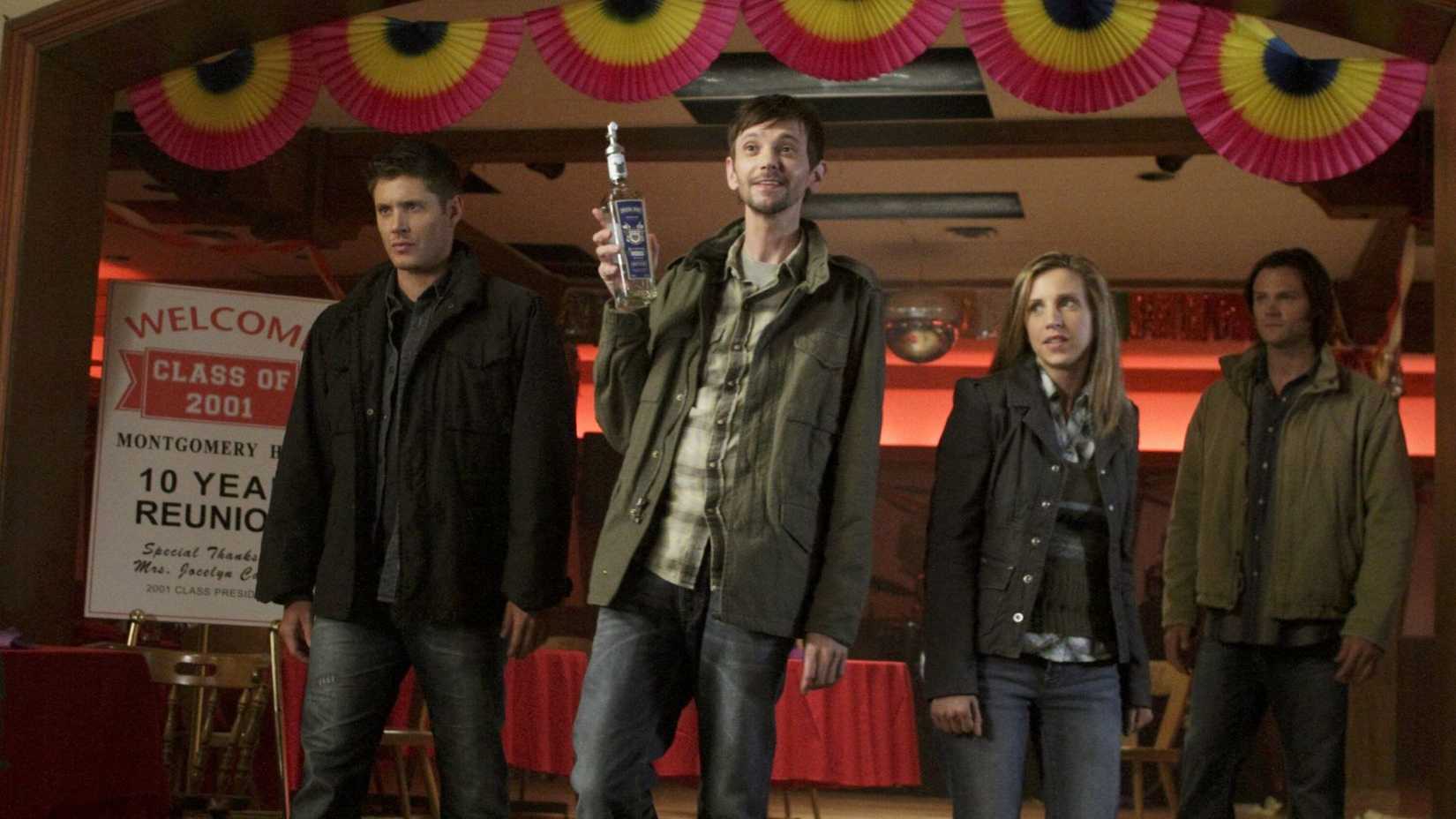 Three men and a woman stand in a brightly decorated lobby