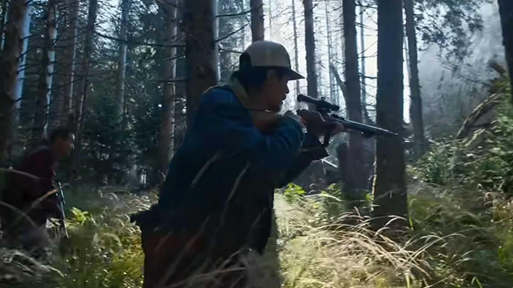 A still from the Hope trailer in which a man stalks a monster through a forest with a gun