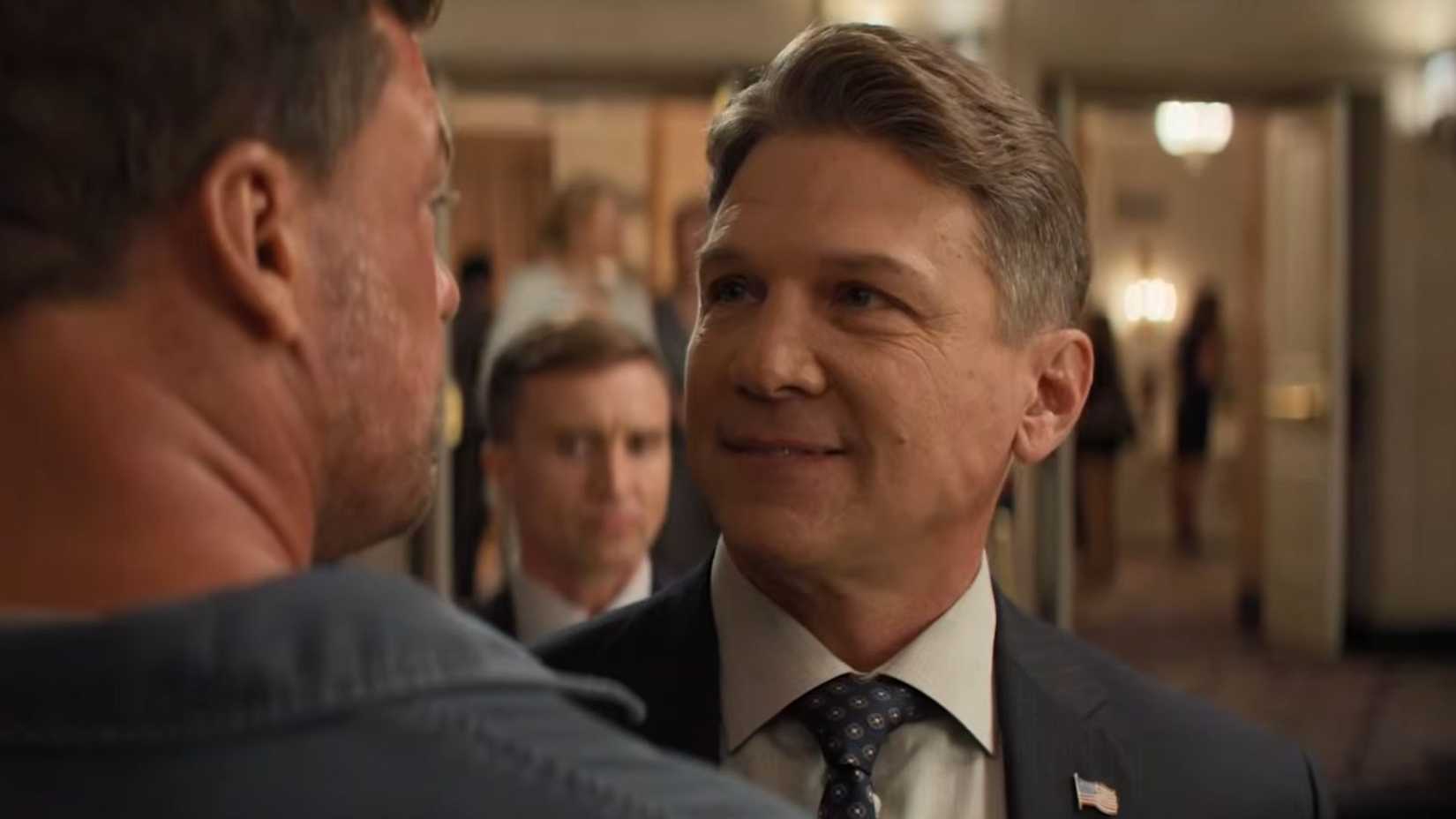 Congressman Sampson (Marc Blucas) smiling awkwardly at Reacher