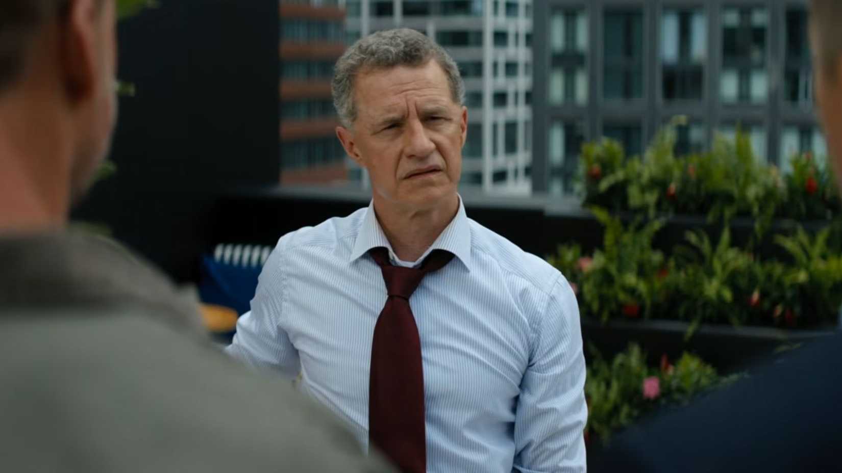 Nolan looking cornered, with Reacher standing in front of him
