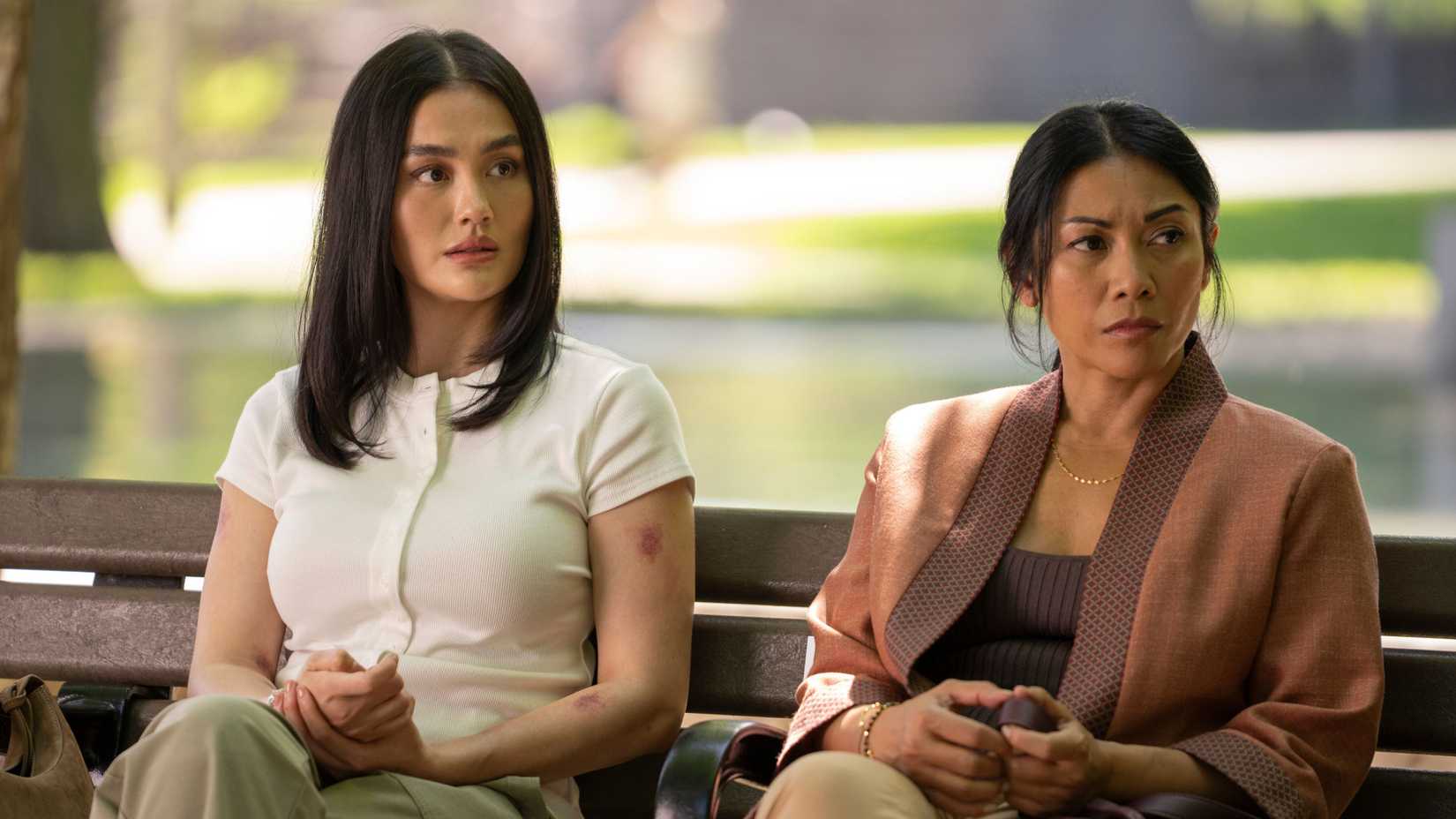 Lila and Amisha sitting on a bench in Reacher season 4
