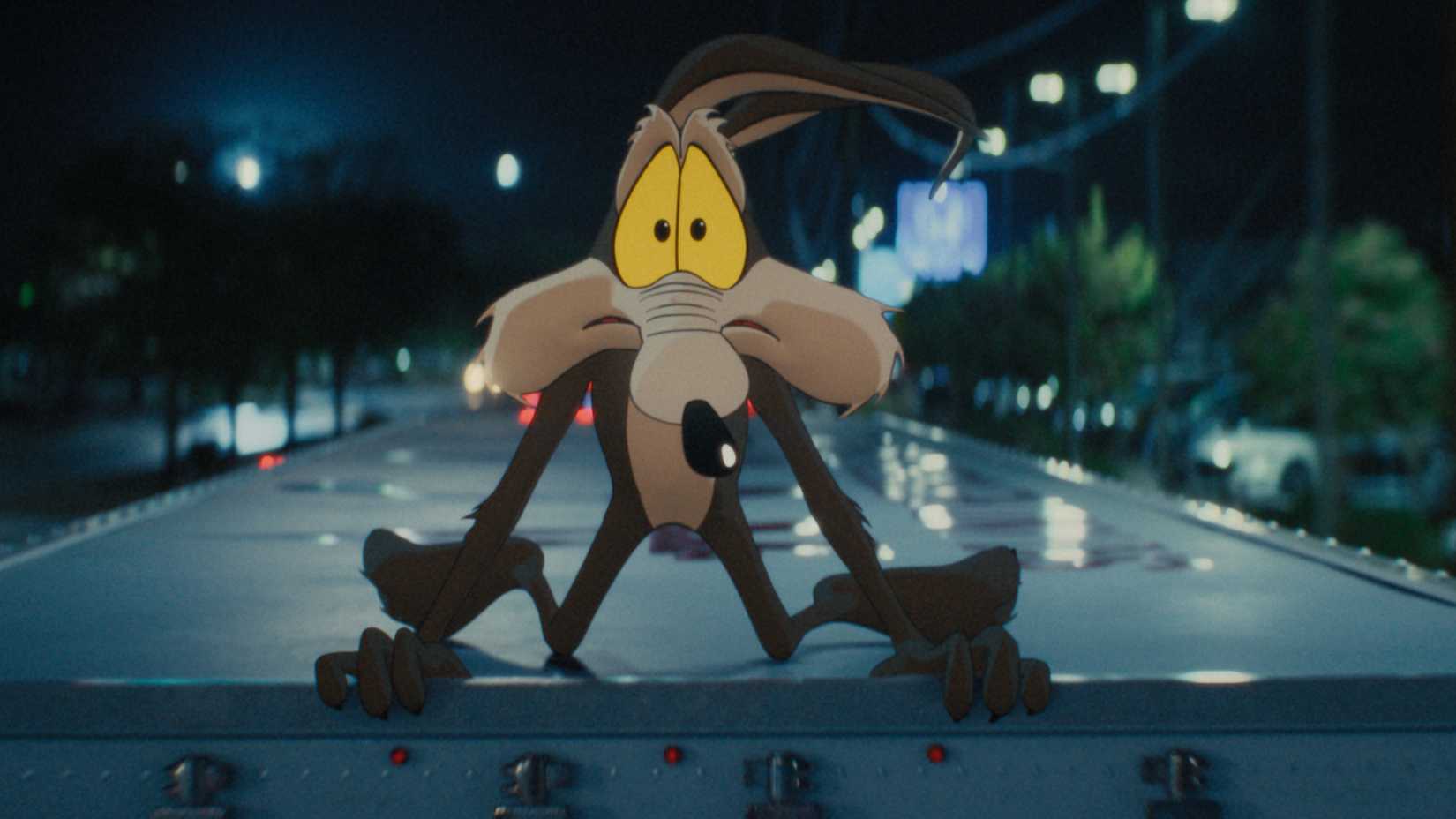 Wile E. Coyote looking worried on top of a moving truck in Coyote vs. Acme