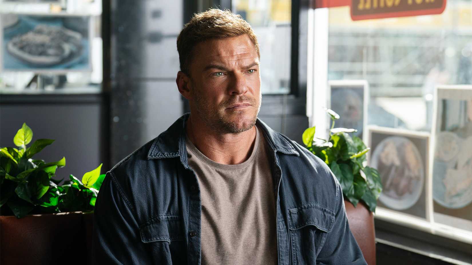 Alan Ritchson’s Jack Reacher sitting in a diner in Prime Video’s Reacher