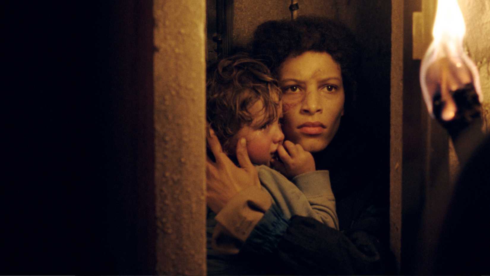 A woman cradles a crying child in Lockdown Tower