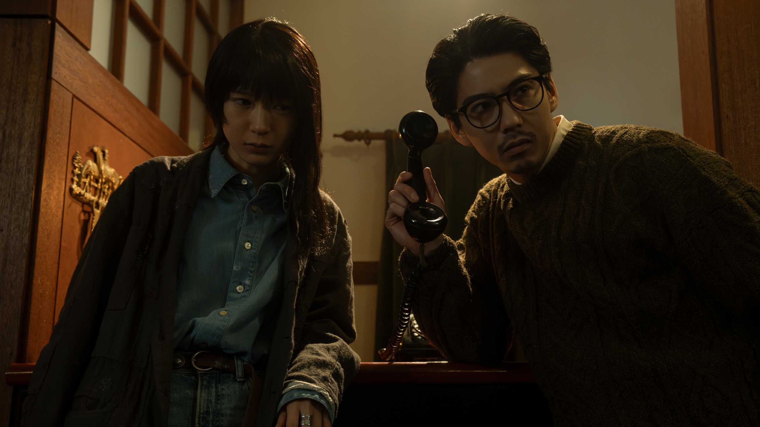 Airi and Gunji holding a phone up to hear a ghostly caller in Never After Dark