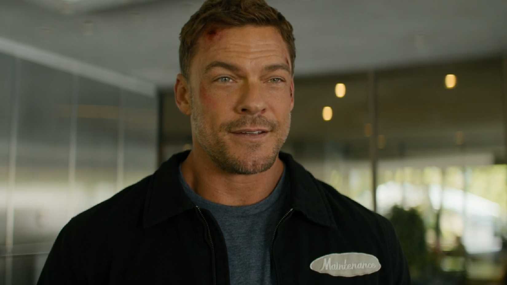 Alan Ritchson as Reacher smiling.
