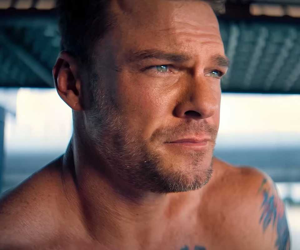 Alan Ritchson looks emotional as he looks out the sea in Runner