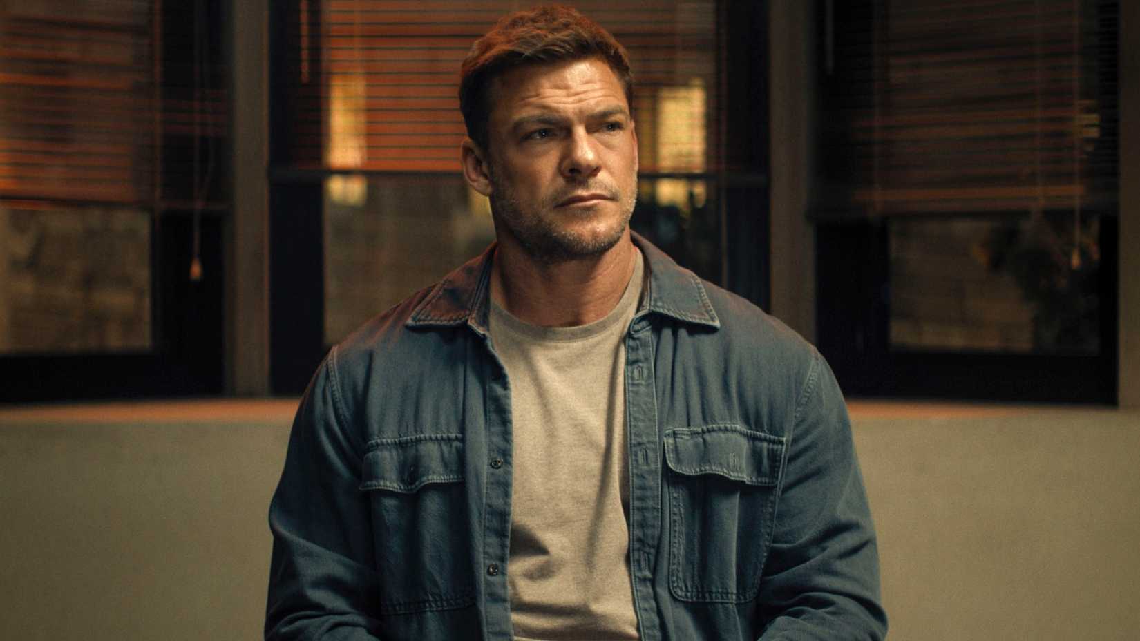Alan Ritchson sitting in Reacher season 4