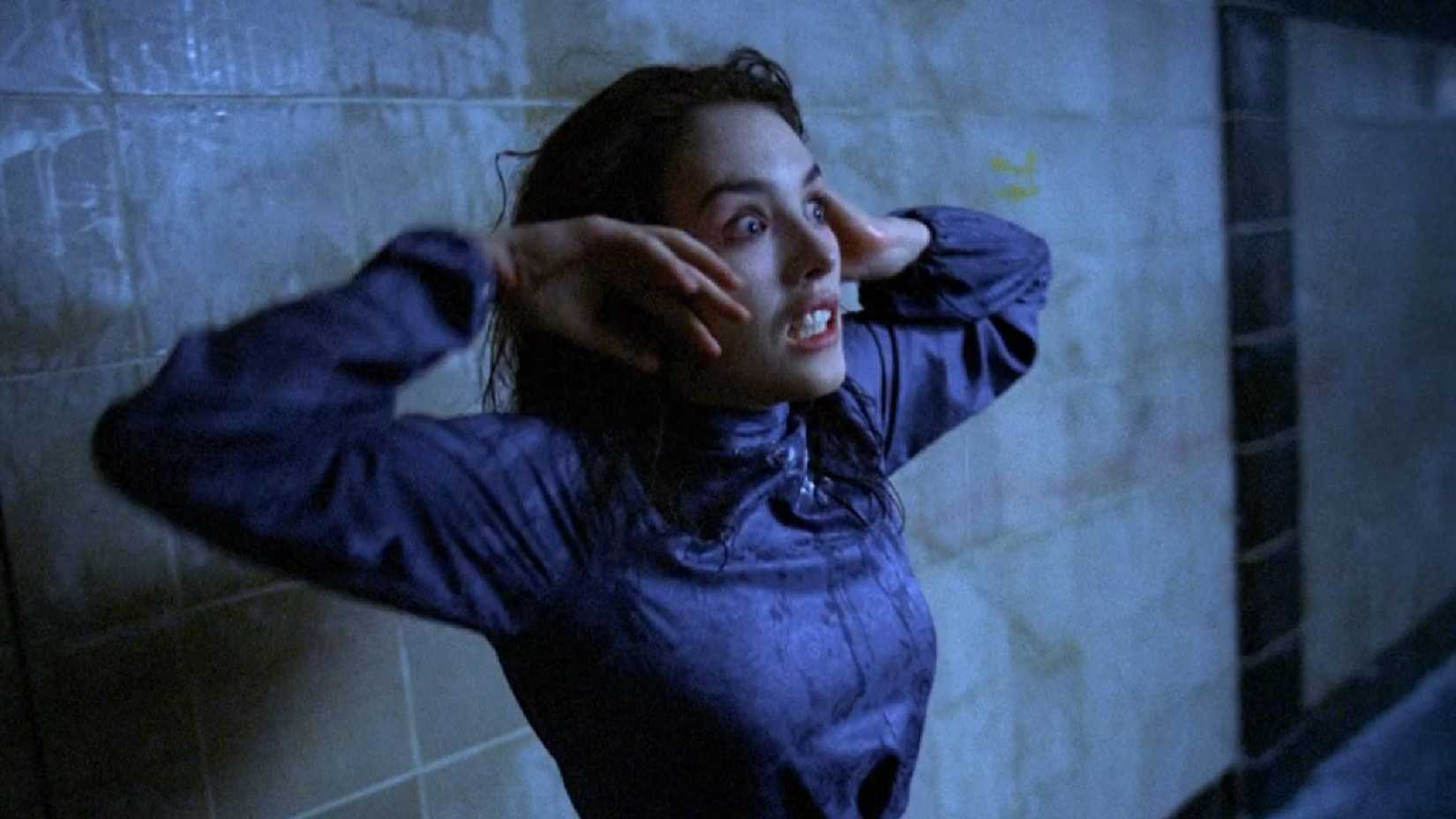 Anna looks shocked against a grey wall in possession