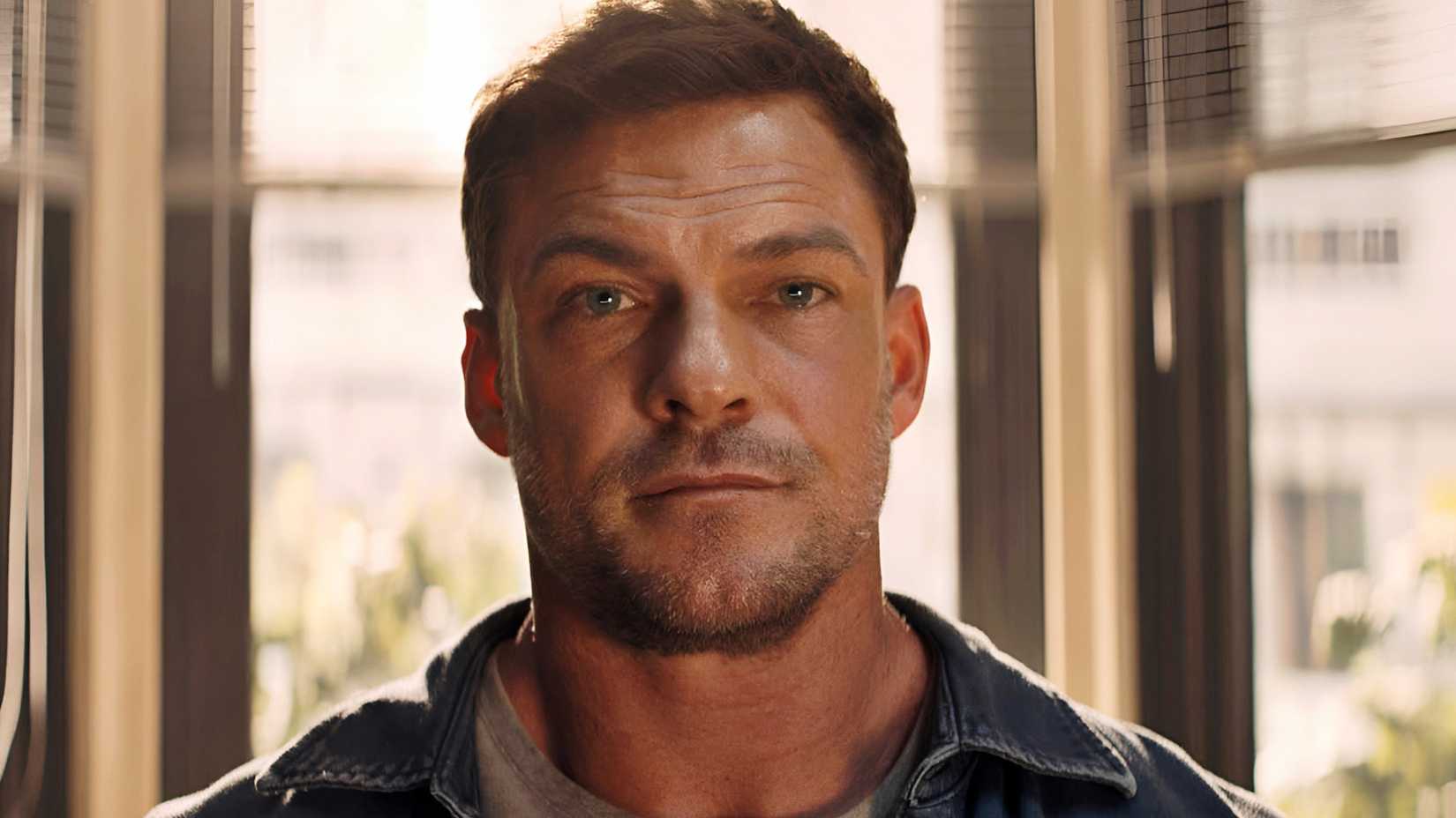 Alan Ritchson’s Reacher with a blank expression on his face in Reacher season 4