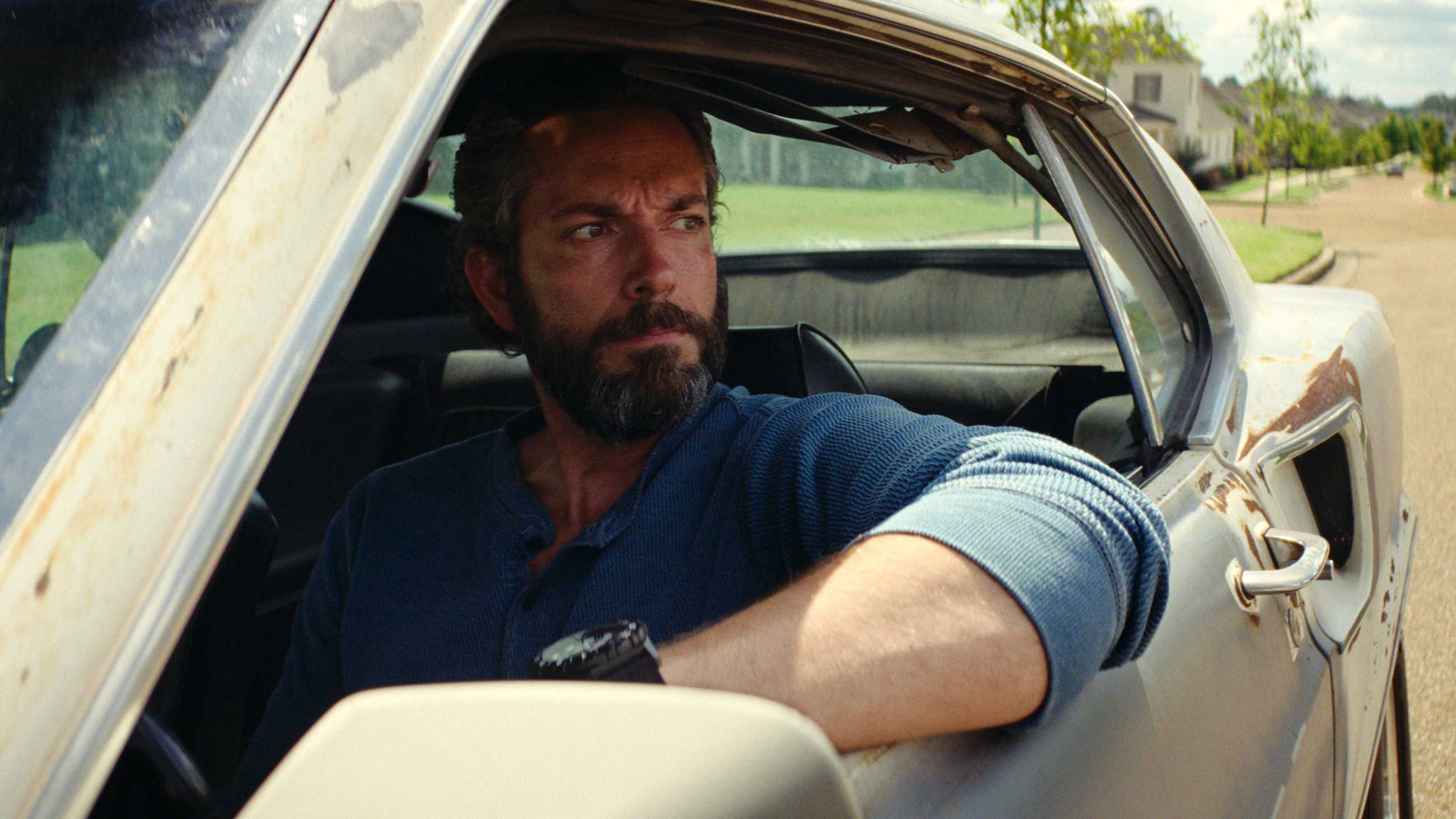 Bearded Zachary Levi looking out the window of a car in The Fix
