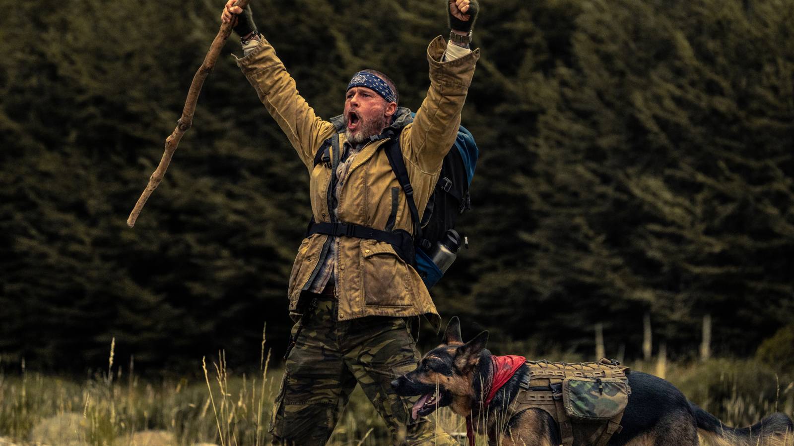 Brad Pitt celebrating with his hands in the air and Odin by his side in Heart of the Beast