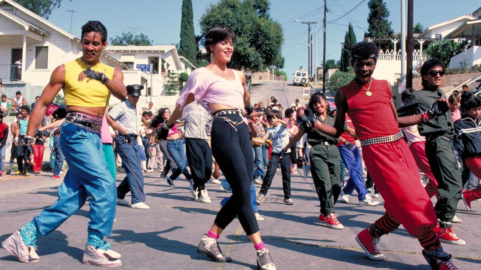 Three dancers performing in front of a crowd in Breakin' 2 Electric Boogaloo.