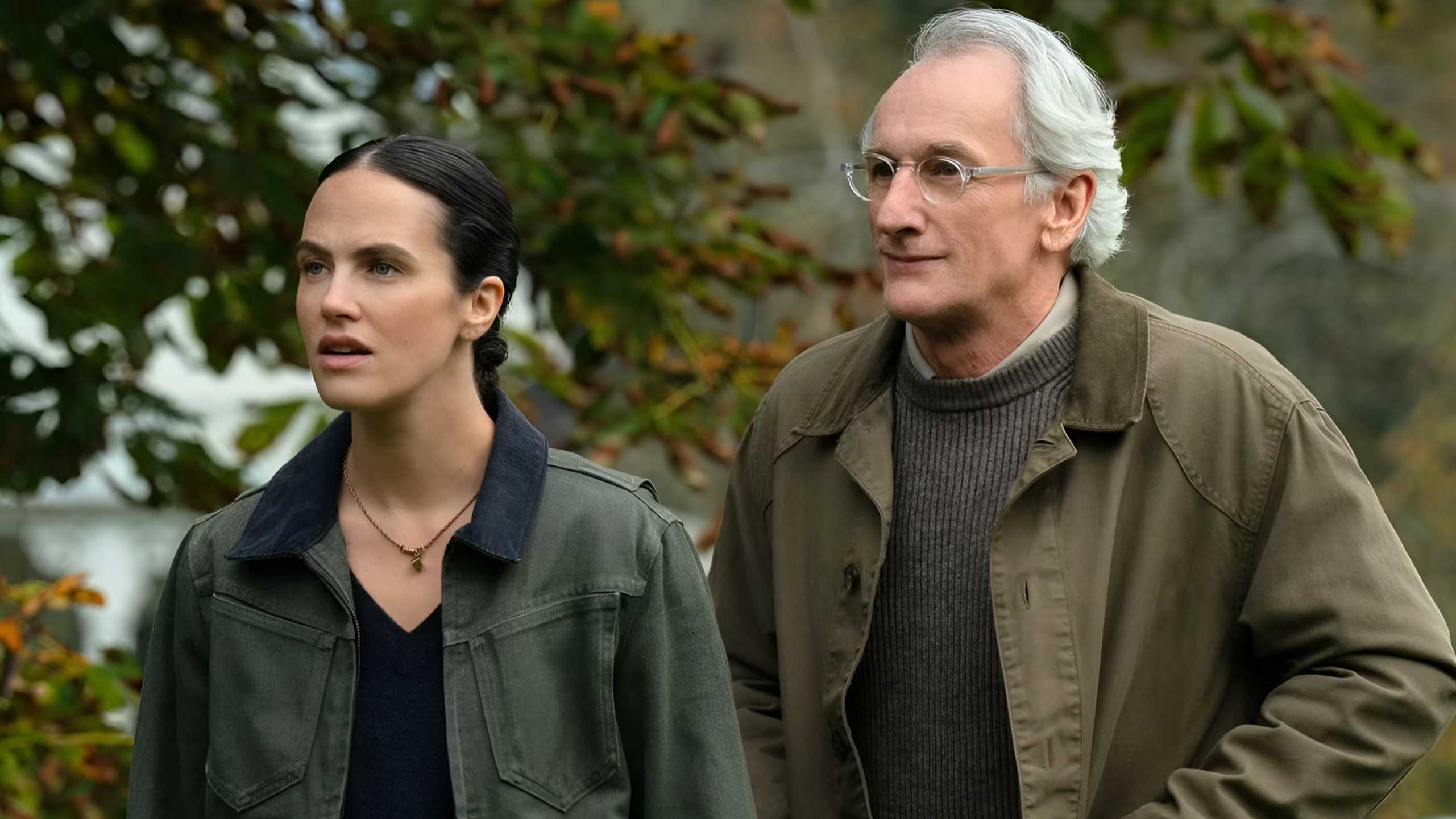 Jessica Brown Findlay’s Charlotte and Matt Craven’s Victor strolling in a park in Silo season 3