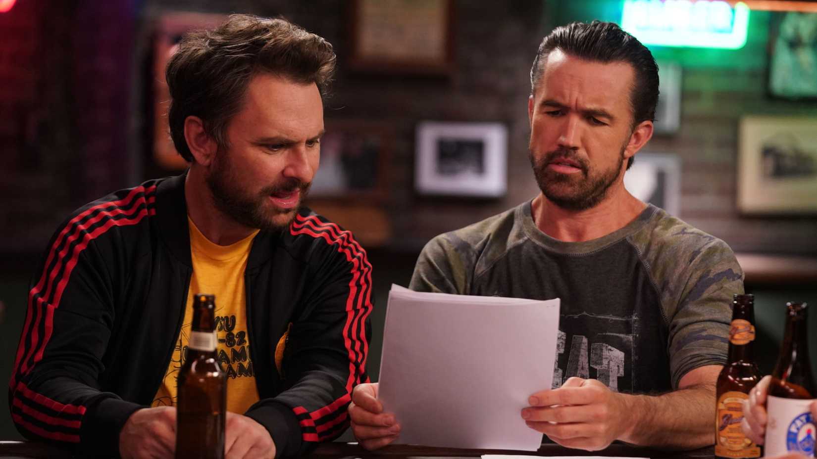 Charlie and Mac looking worriedly at a sheet of paper in It's Always Sunny in Philadelphia season 18