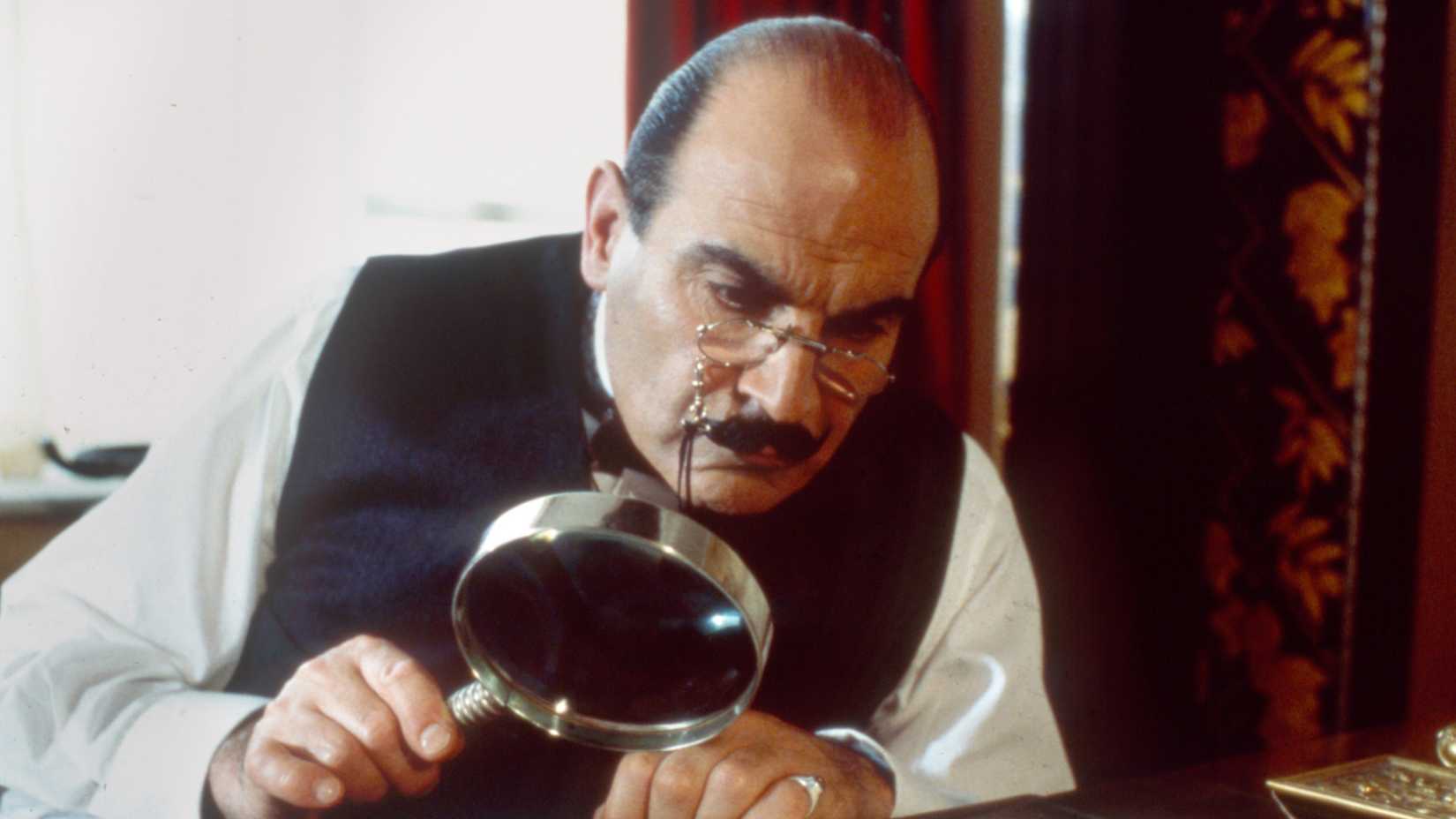 David Suchet as Hercule Poirot using a magnifying glass in Agatha Christie's Poirot 2000