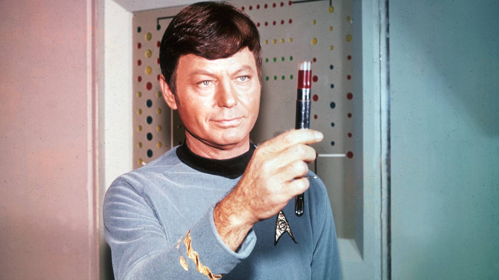 DeForest Kelley as Bones McCoy holding up a hypospray