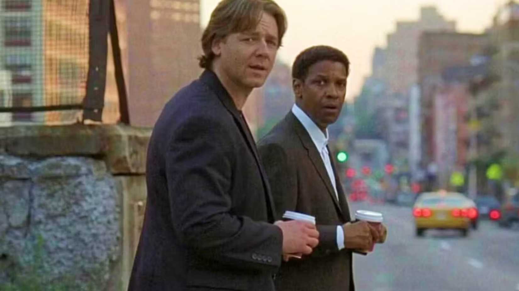 Denzel Washington and Russell Crowe stand together in American Gangster