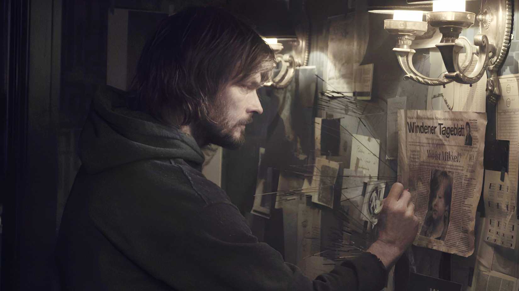 Andreas Pietschmann‘s The Stranger navigating newspaper clippings on a wall in Netflix’s Dark