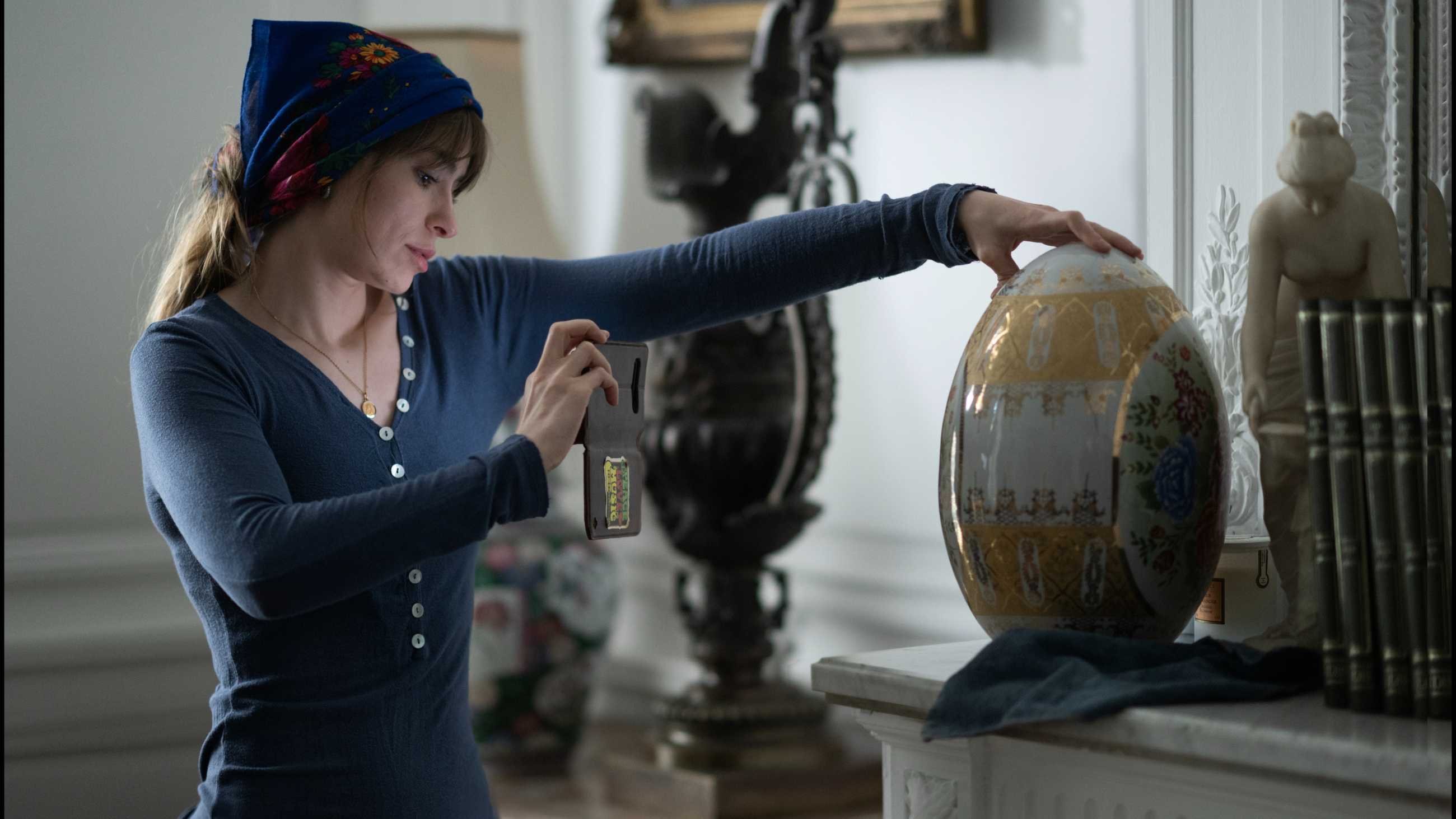 Gianina taking a picture of an egg sculpture in The Diary of a Chambermaid