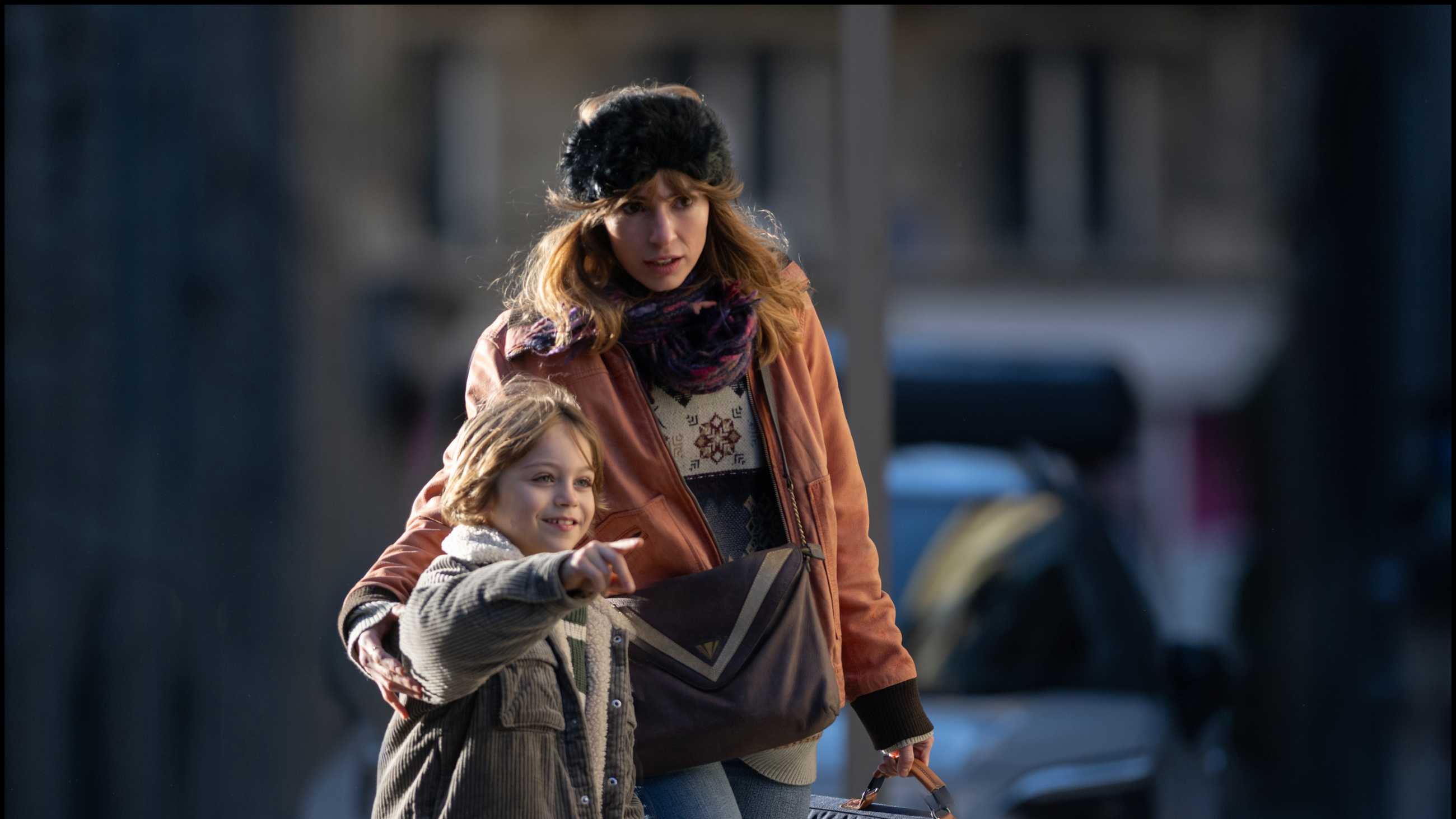 Gianina walking with a young girl, who points at something for her to look at