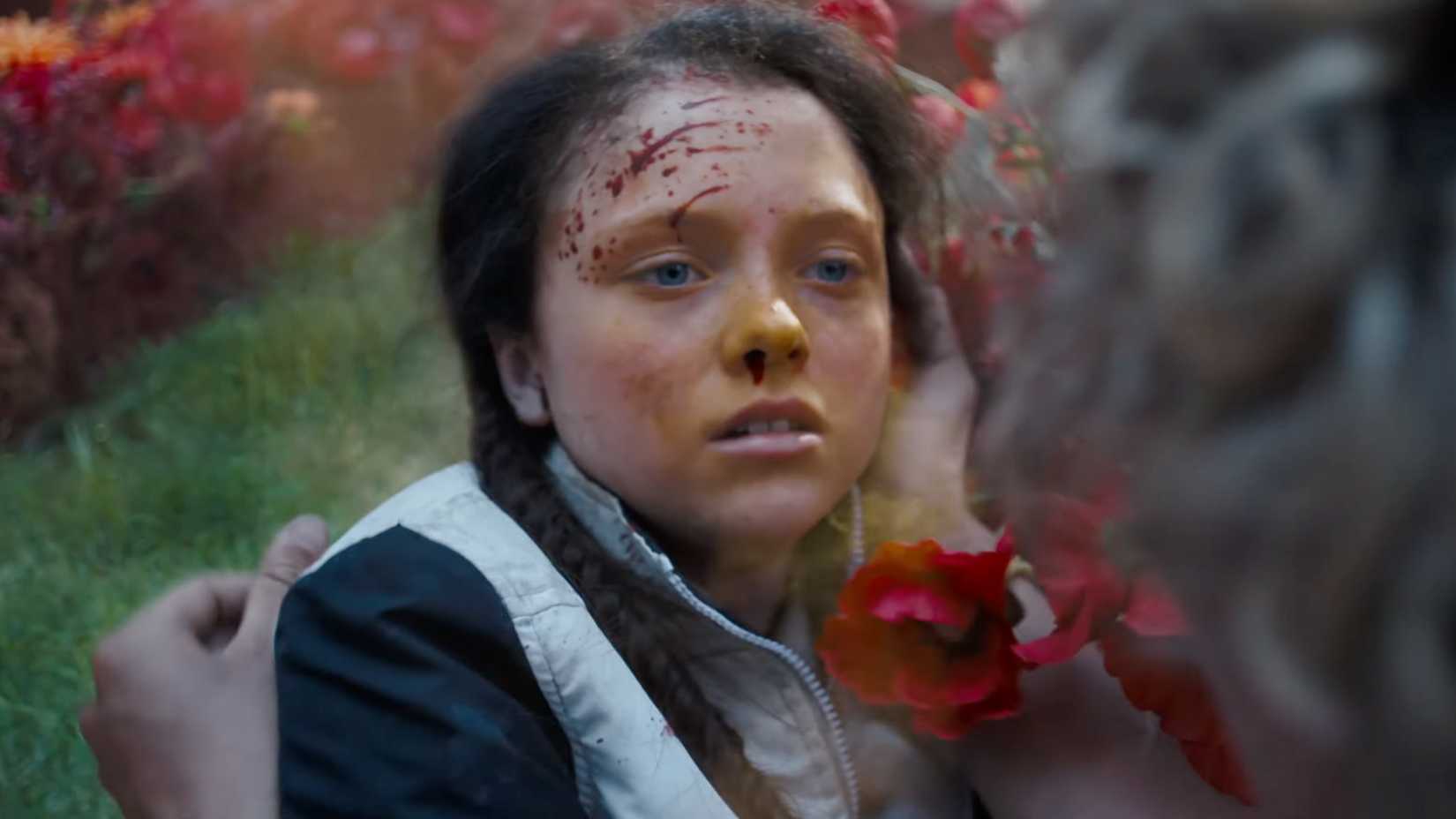 Haymitch holding Lou Lou after she's been poisoned in Hunger Games Sunrise on the Reaping