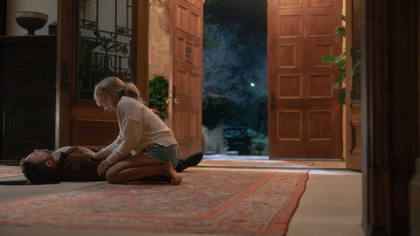 Jai Courtney lying on the floor with Natalie Alyn Lind sitting next to him in Dutton Ranch