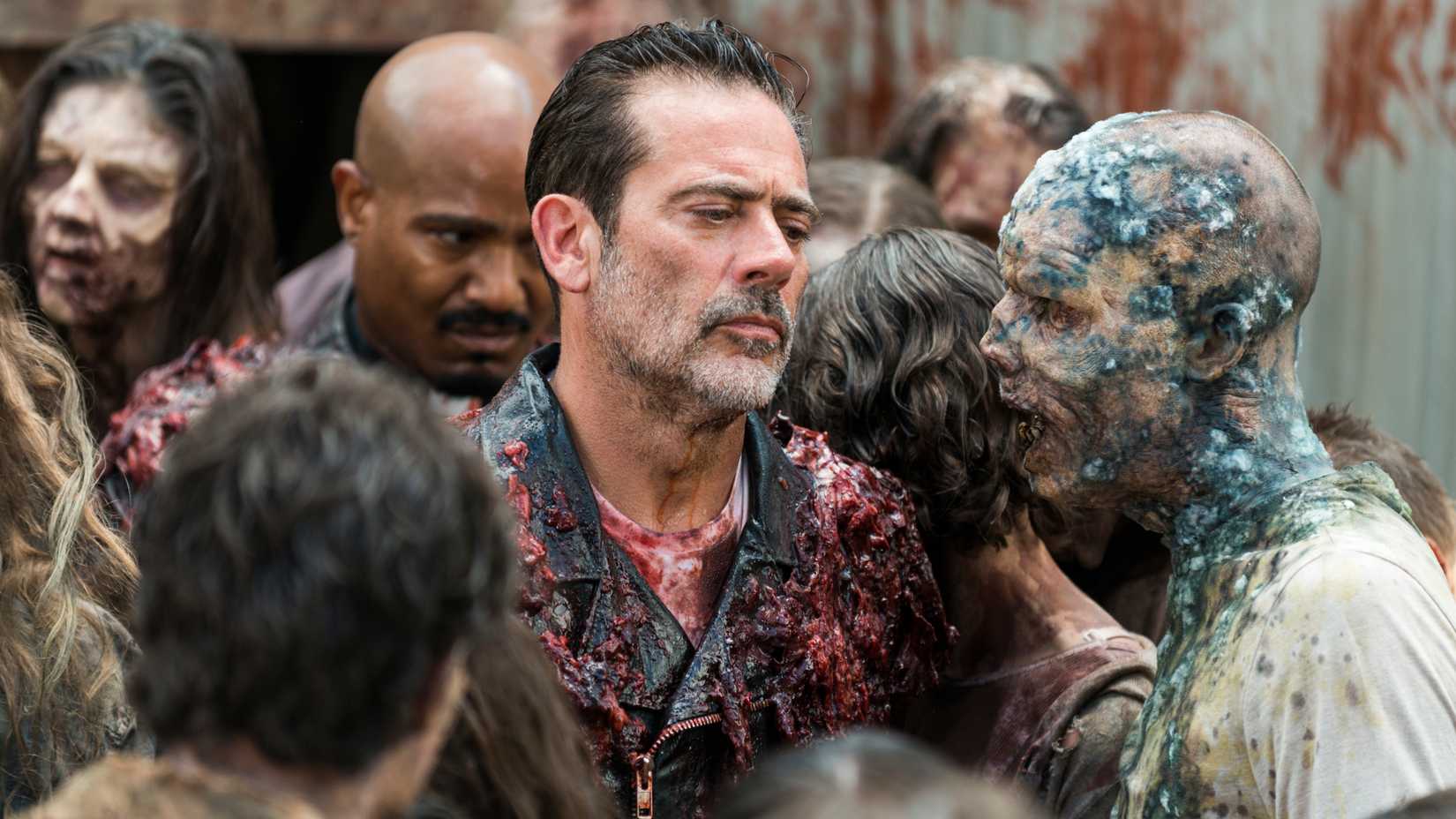 Jeffrey Dean Morgan as Negan with Father Gabriel (Seth Gilliam) behind him walking through a horde while covered in guts in The Walking Dead