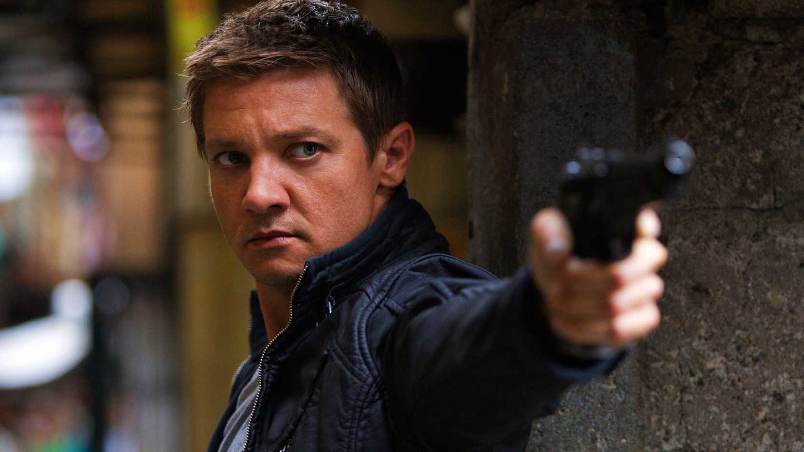 Jeremy Renner as Aaron Cross pointing a gun in The Bourne Legacy