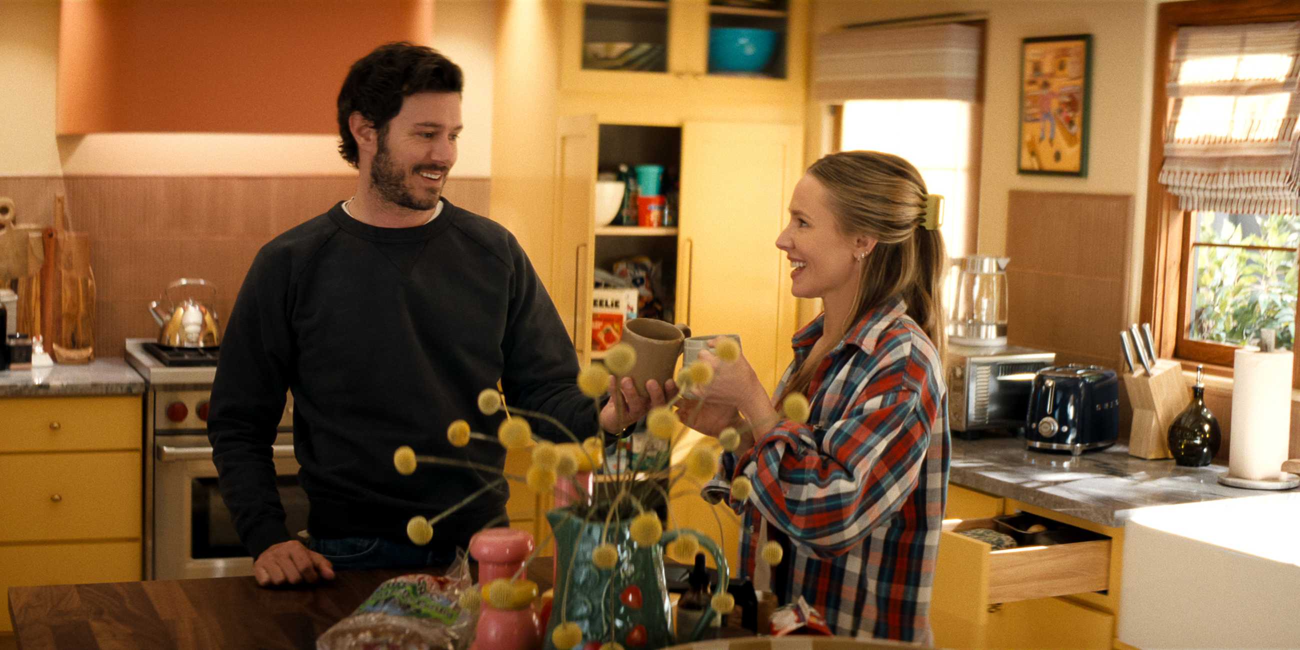 Joanne and Noah clinking mugs together and smiling in Nobody Wants This season 3