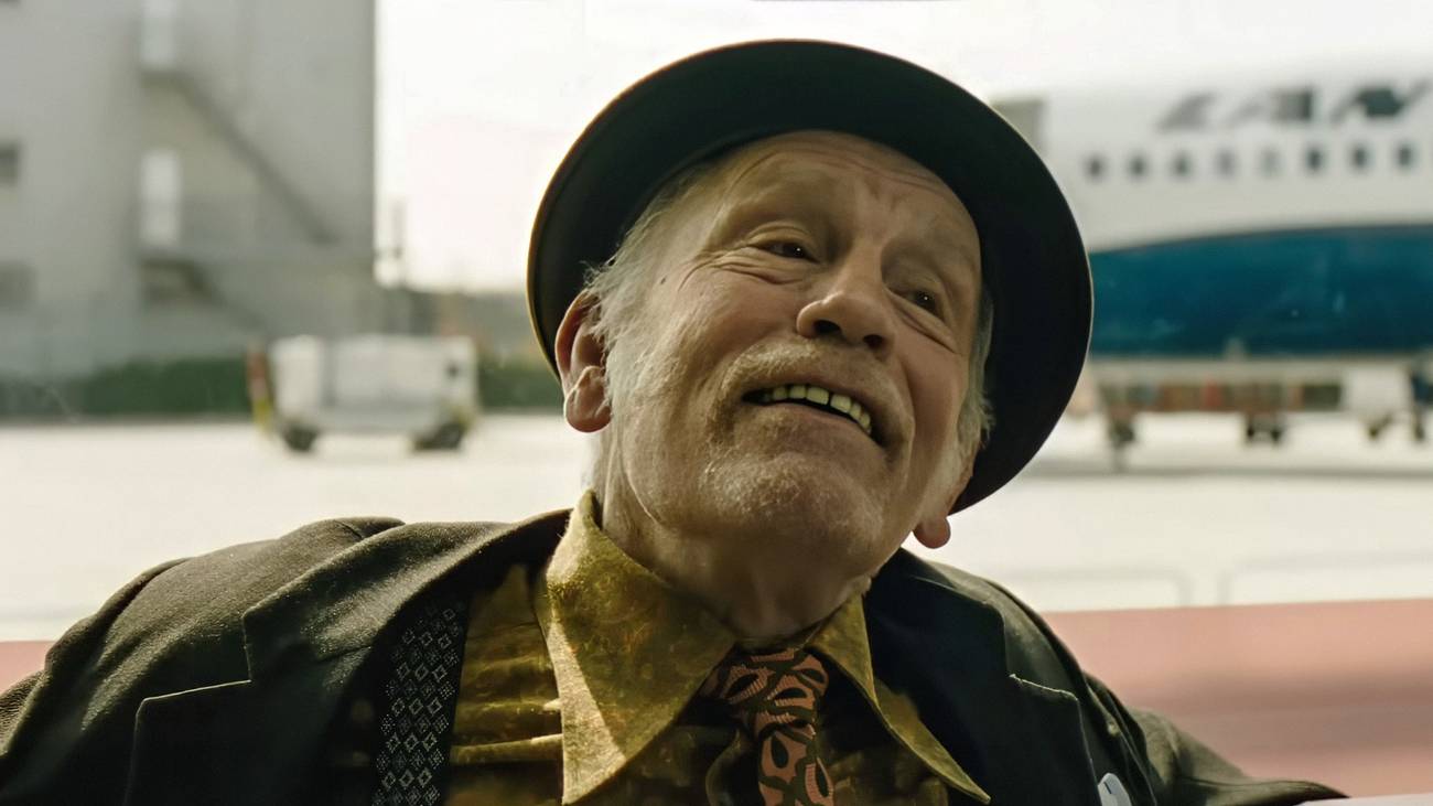 John Malkovich grinning and tilting his head in Wild Horse Nine